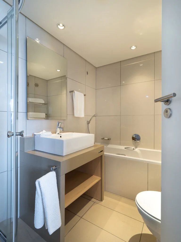 Cette salle de bain carrelée allie fonctionnalité et esthétique, créant un espace à la fois pratique et agréable à utiliser par une Entreprise de rénovation en Isère