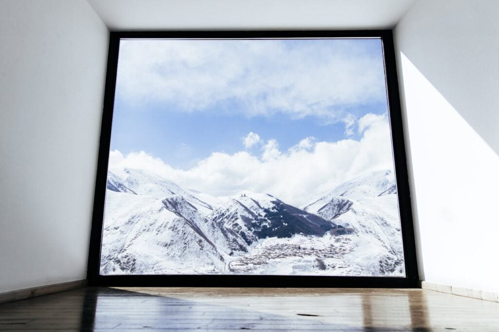 Imaginez une fenêtre encadrant majestueusement une haute montagne, capturant la grandeur des sommets enneigés et la beauté sauvage de la nature, conçue par un menuisier en Isère.